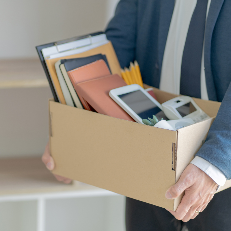 A man with a cardboard box full of belongings