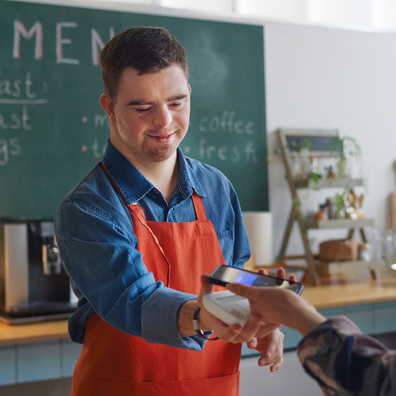 Disabled worker taking payment in a cafe. 