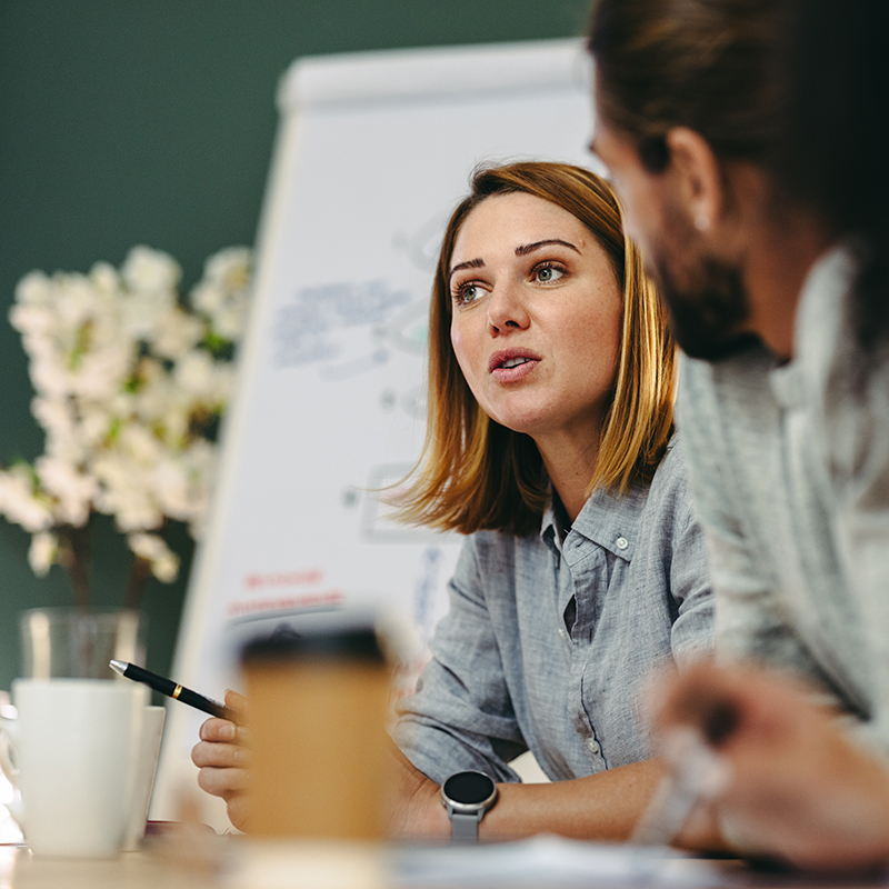 Young female employee owner in a meeting with other employee owners.