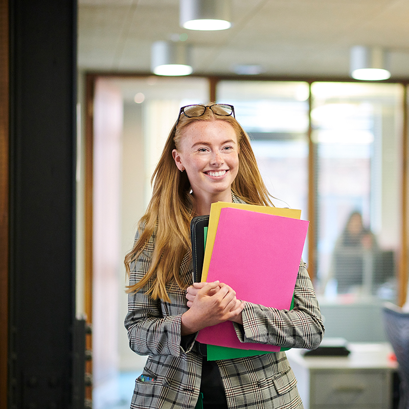 Happy young employee walking through the office