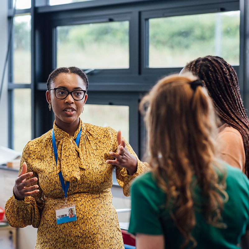 A shot of an employee talking to potential business partners at a networking event.