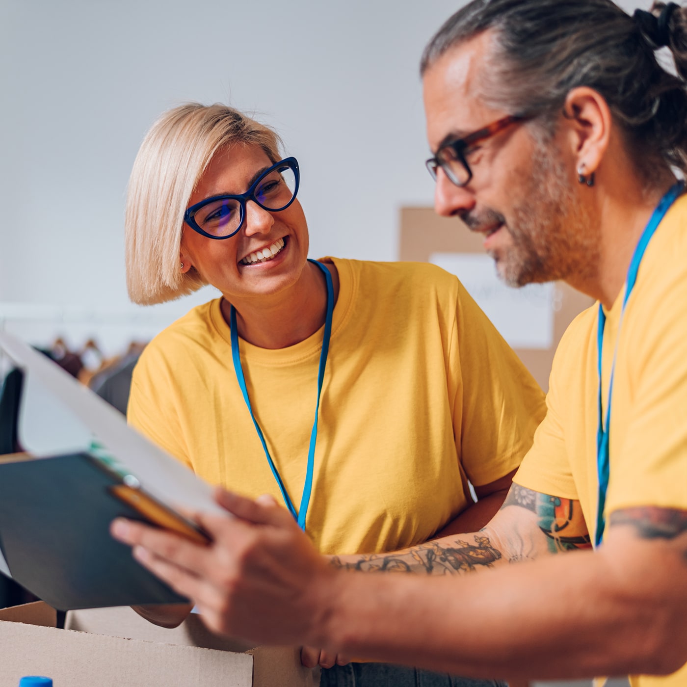 Two adults looking over work documents whilst smiling.